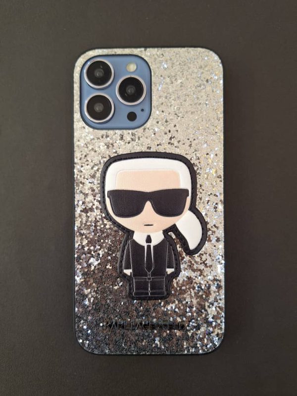 کاور گوشی موبایل آیفون 14 پرومکس iPhone14Promax طرح کارل لاگرفلد Karl Lagerfeld اکلیلی رنگ نقره ای طرح برجسته